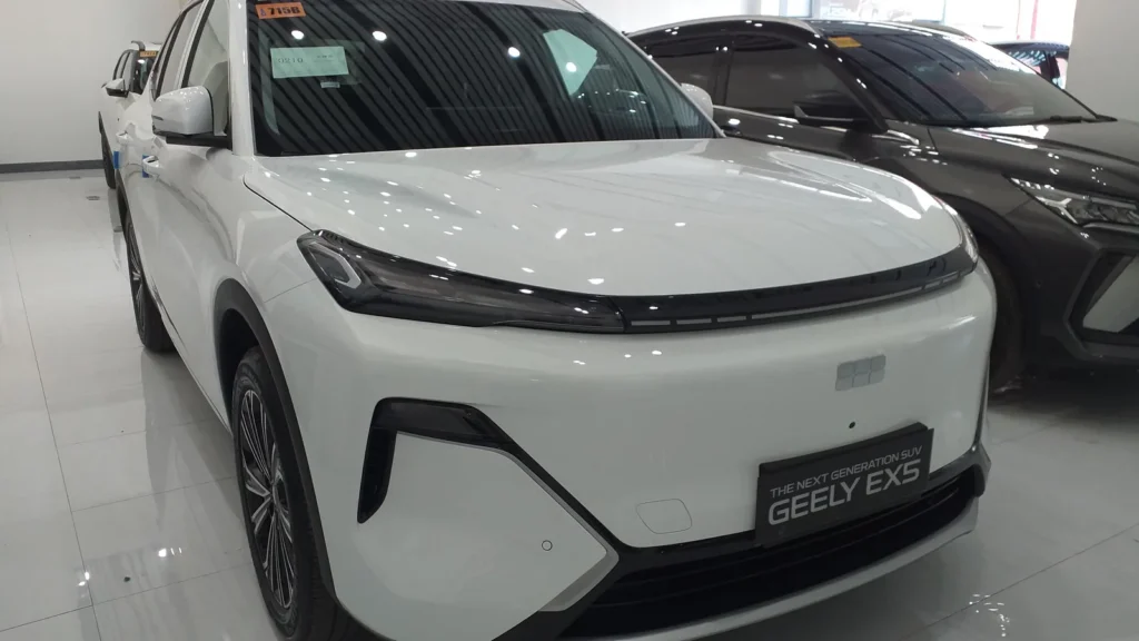 Белый подключаемый гибрид Geely EX5 EM-i в автосалоне